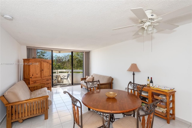 dining space featuring light tile patterned floors, a textured ceiling, and a wall of windows