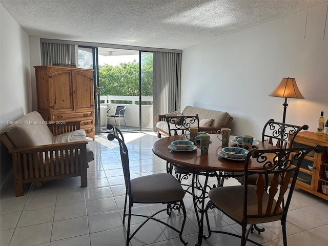 dining space with expansive windows, a textured ceiling, and light tile patterned floors