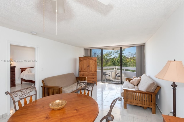 dining area featuring expansive windows, a textured ceiling, and light tile patterned flooring