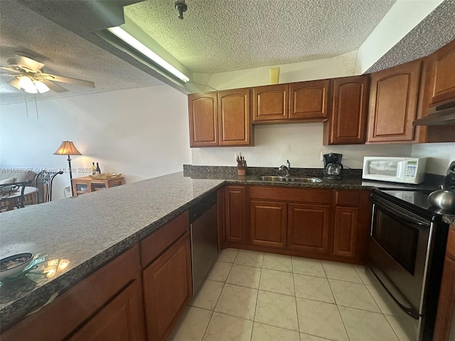 kitchen featuring light tile patterned flooring, sink, a textured ceiling, ceiling fan, and stainless steel appliances