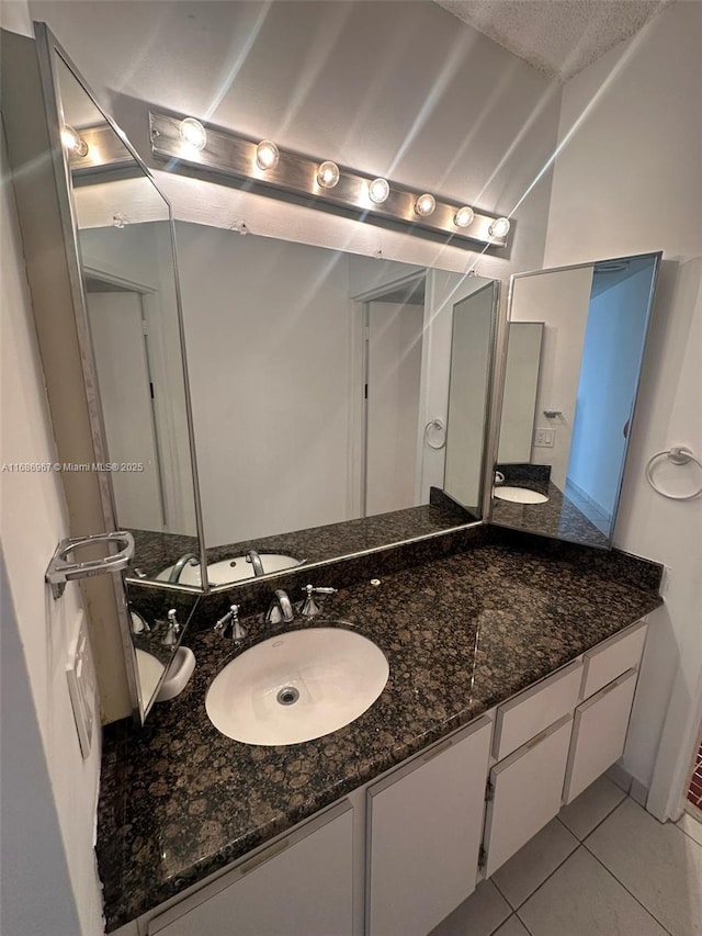 bathroom featuring tile patterned flooring, vanity, and a textured ceiling