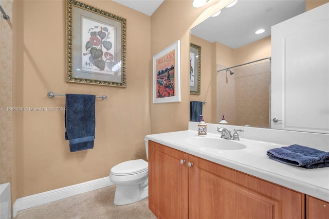 bathroom with vanity, toilet, tile patterned floors, and tiled shower