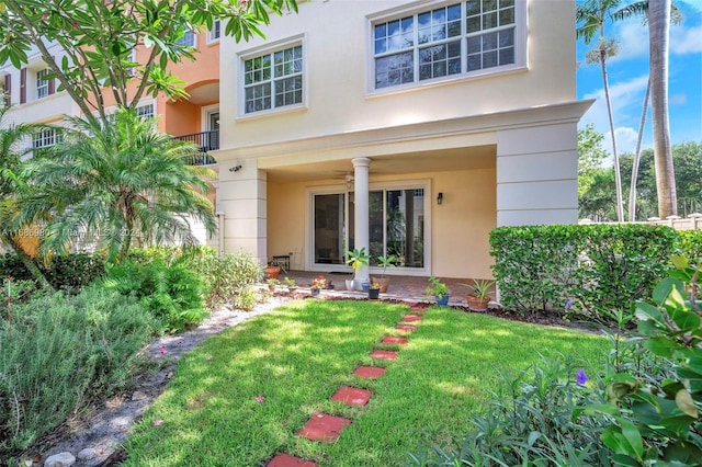 entrance to property featuring a yard and a balcony