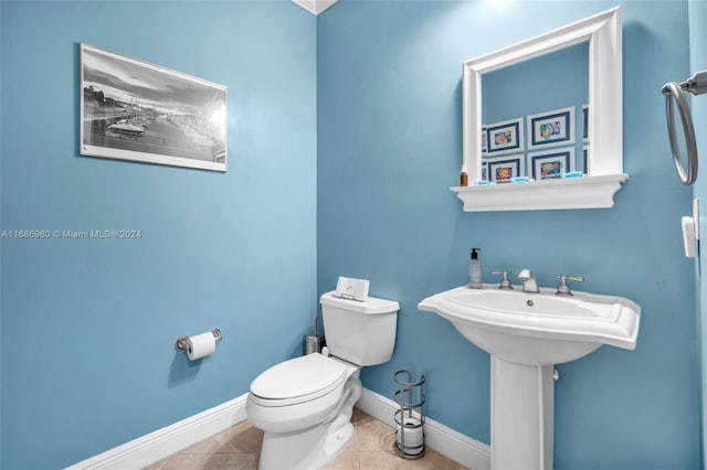 bathroom featuring toilet, sink, and tile patterned flooring