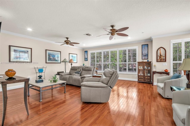 living room with ornamental molding, hardwood / wood-style floors, a textured ceiling, and ceiling fan