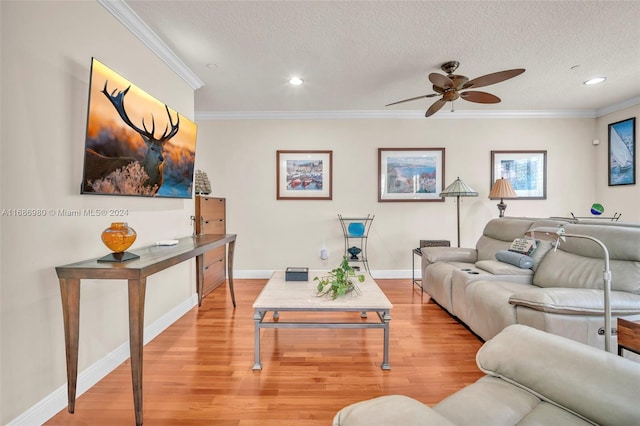 living room featuring crown molding, a textured ceiling, light wood-type flooring, and ceiling fan