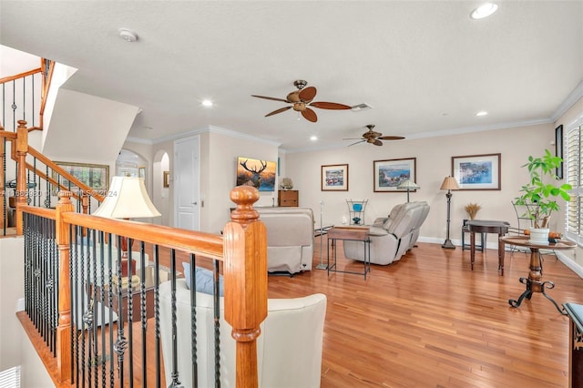 living room featuring light hardwood / wood-style floors, crown molding, a textured ceiling, and ceiling fan