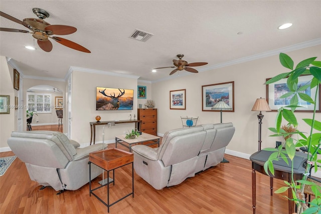 living room featuring light hardwood / wood-style flooring, ornamental molding, and ceiling fan