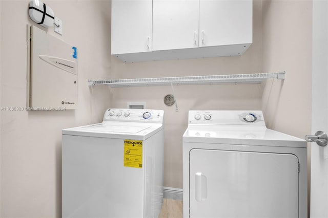 laundry room with washer and dryer and cabinets