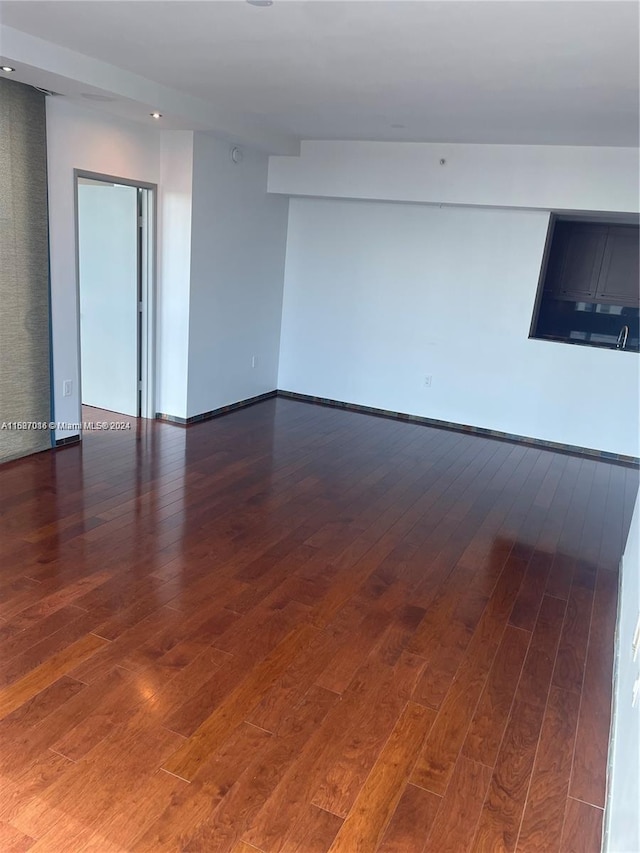 unfurnished room with dark wood-type flooring