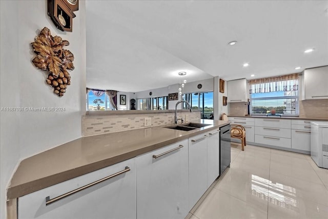 kitchen featuring sink, decorative light fixtures, white cabinets, decorative backsplash, and light tile patterned floors