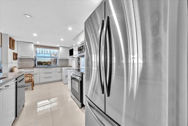 kitchen with white cabinetry, tasteful backsplash, stainless steel appliances, and light tile patterned floors