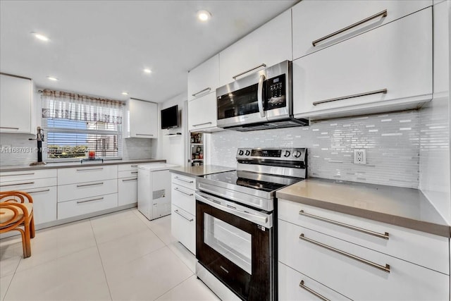 kitchen with white cabinets, stainless steel appliances, and backsplash