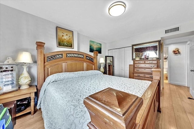 bedroom with light hardwood / wood-style floors and a closet