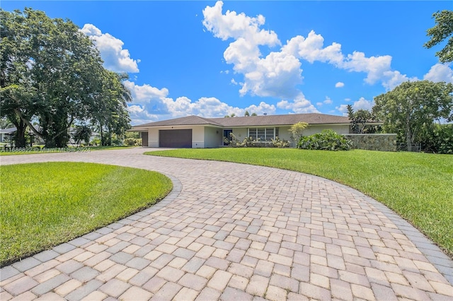 ranch-style home featuring a garage and a front lawn