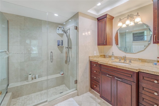 bathroom featuring a shower with shower door, vanity, and tile patterned floors