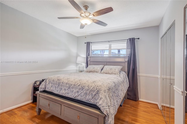 bedroom with hardwood / wood-style floors, ceiling fan, and a closet