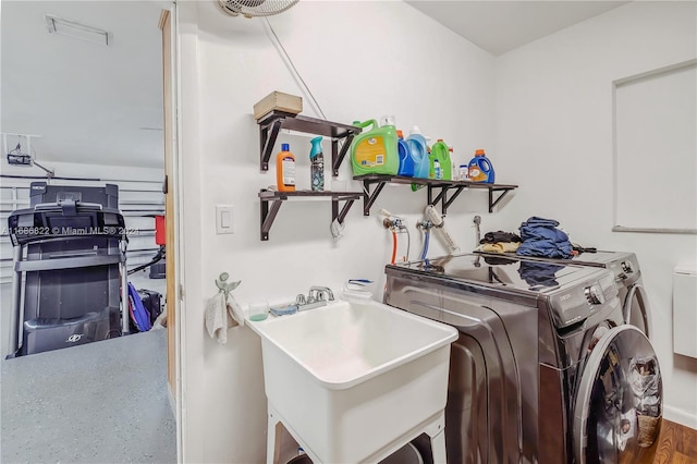 laundry room with hardwood / wood-style flooring, sink, and independent washer and dryer