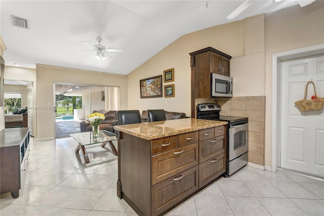 kitchen featuring light tile patterned flooring, stainless steel appliances, light stone countertops, lofted ceiling, and ceiling fan