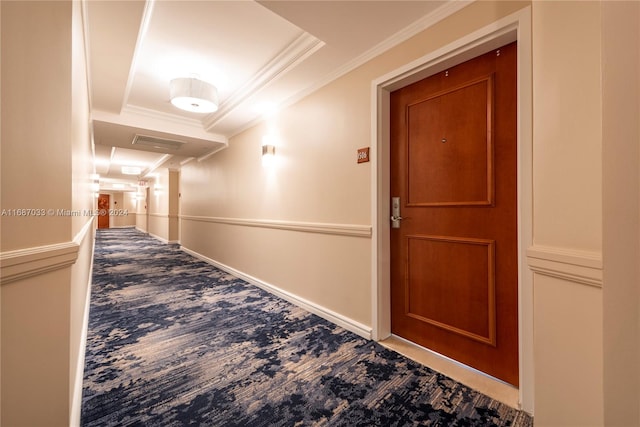 corridor featuring carpet flooring, a raised ceiling, and ornamental molding