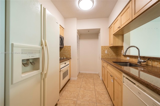 kitchen featuring tasteful backsplash, sink, light tile patterned floors, and white appliances