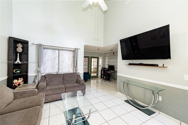 tiled living room with french doors, a towering ceiling, and ceiling fan