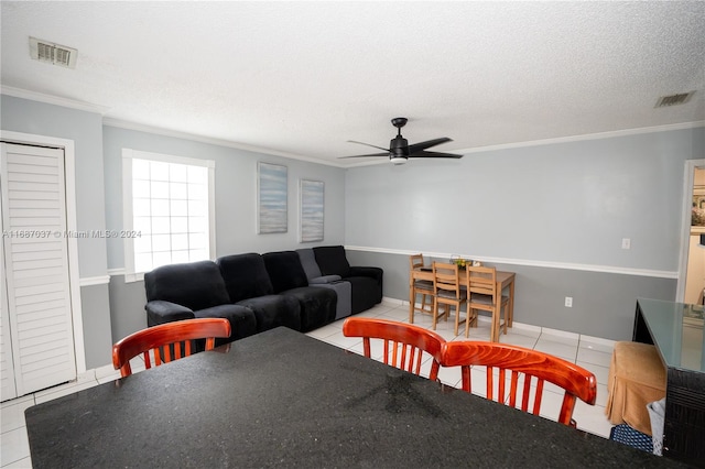 tiled dining space with crown molding, a textured ceiling, and ceiling fan