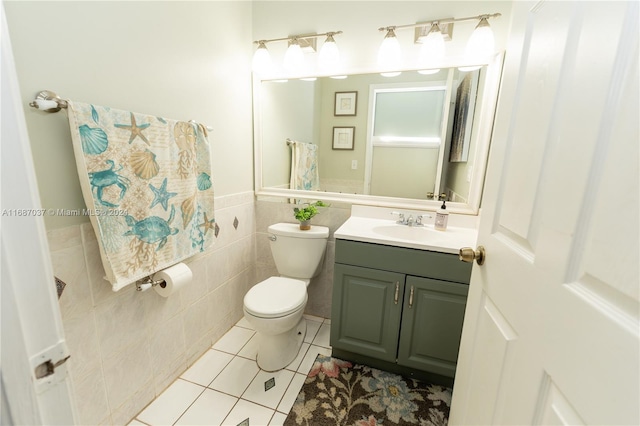 bathroom with vanity, toilet, tile patterned floors, and tile walls