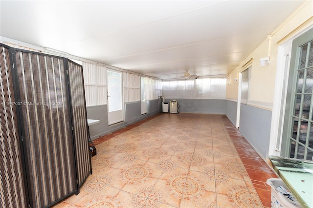 unfurnished sunroom with ceiling fan