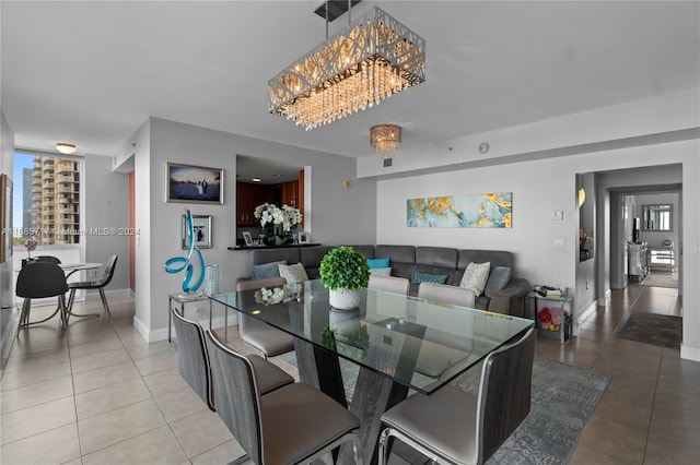 dining space with tile patterned flooring and a chandelier