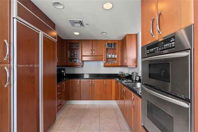 kitchen featuring double oven, light tile patterned flooring, and paneled refrigerator