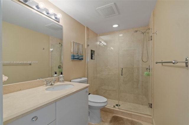 bathroom with tile patterned floors, vanity, toilet, and walk in shower