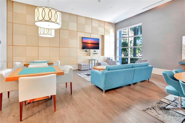 living room featuring light hardwood / wood-style floors and tile walls