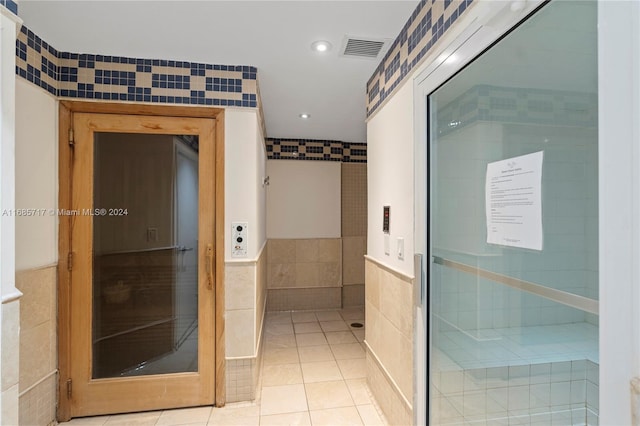 interior space with tile patterned flooring and tile walls