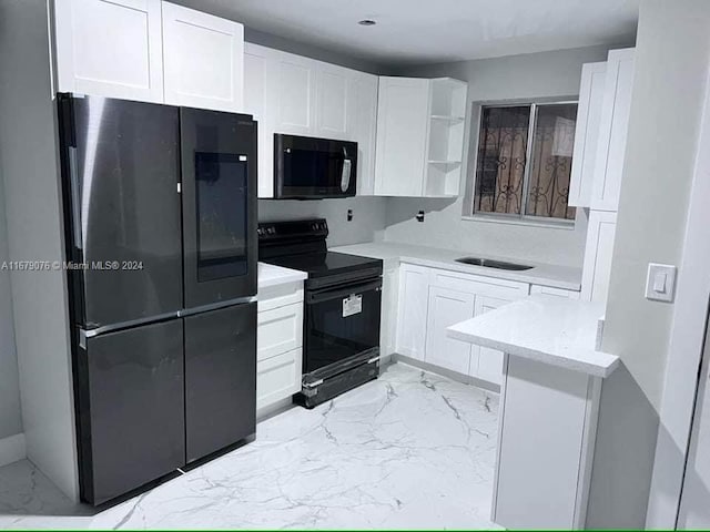 kitchen with white cabinetry, black appliances, sink, and light stone counters