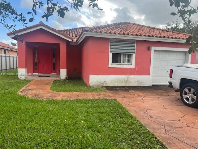 view of front of property featuring a garage and a front lawn