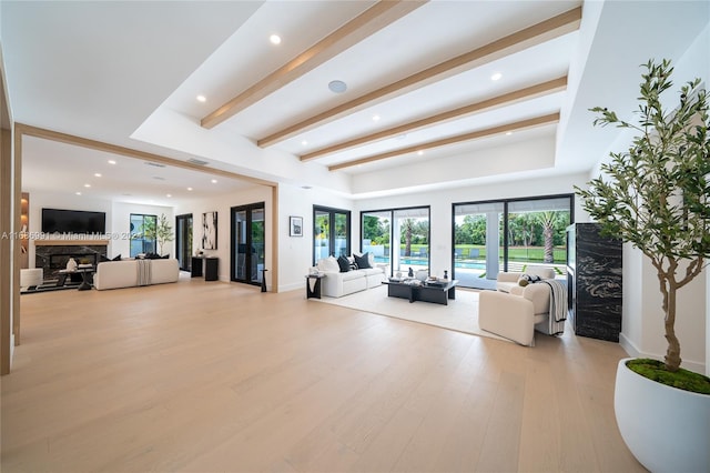 living room with french doors, beamed ceiling, and light wood-type flooring