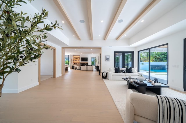 living room featuring beamed ceiling, french doors, and light wood-type flooring