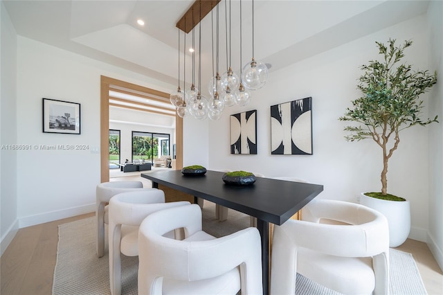 dining area with light hardwood / wood-style flooring and a chandelier