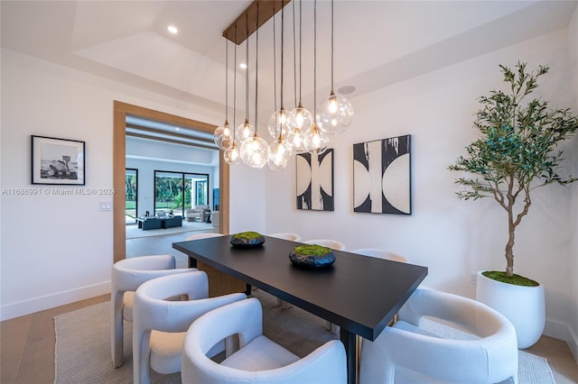 dining space featuring hardwood / wood-style floors and a raised ceiling