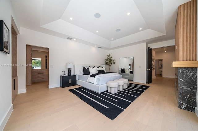 bedroom featuring light hardwood / wood-style flooring and a raised ceiling