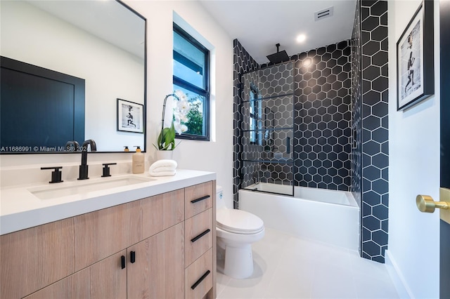 full bathroom with tiled shower / bath, vanity, toilet, and tile patterned floors