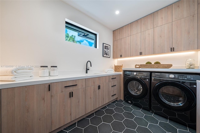 laundry room featuring cabinets, sink, washing machine and clothes dryer, and dark tile patterned floors