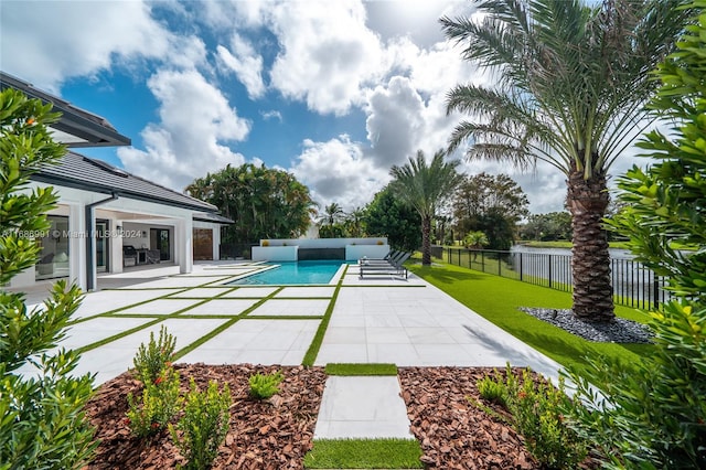 view of swimming pool with a patio area, a lawn, and a water view