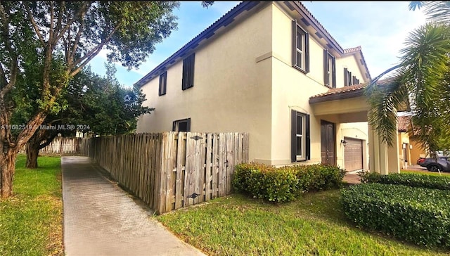 view of side of property with a yard and a garage