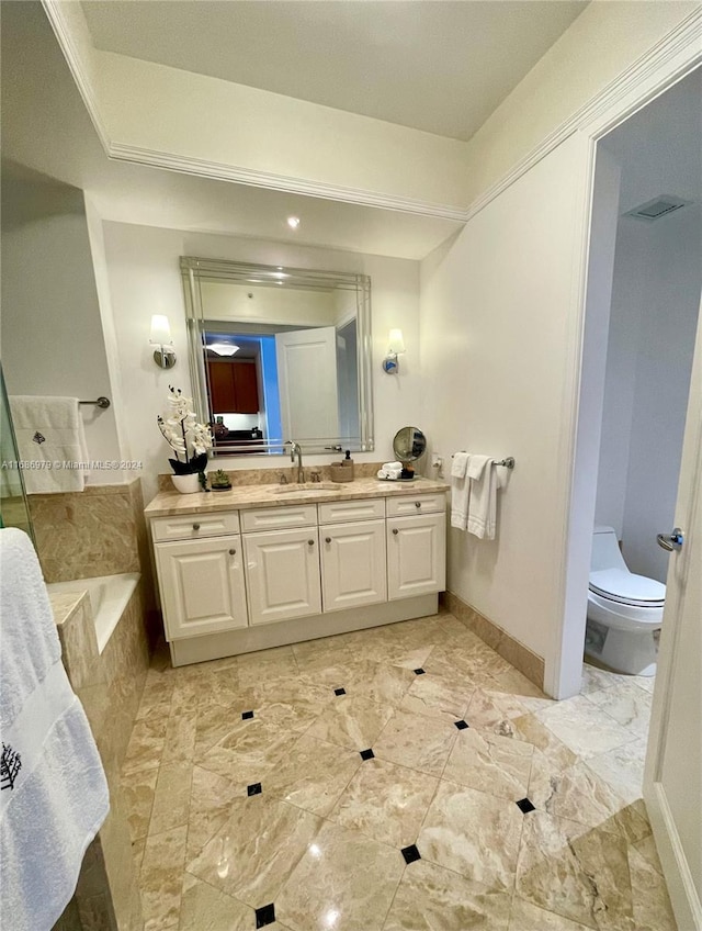 bathroom with vanity, tiled bath, and toilet