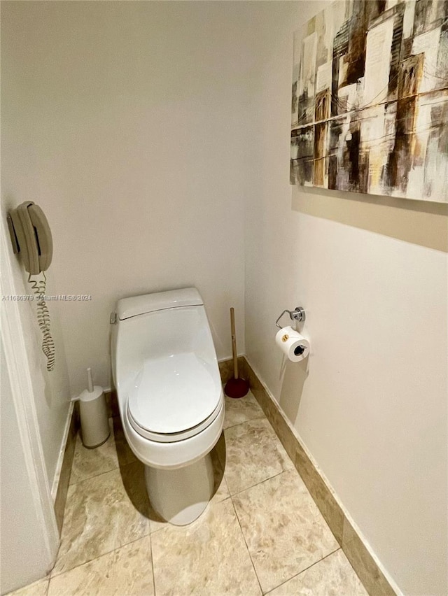 bathroom featuring toilet and tile patterned flooring