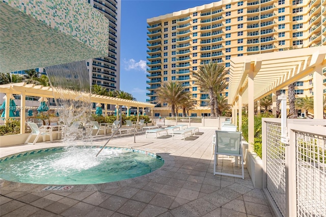 view of swimming pool featuring pool water feature and a patio