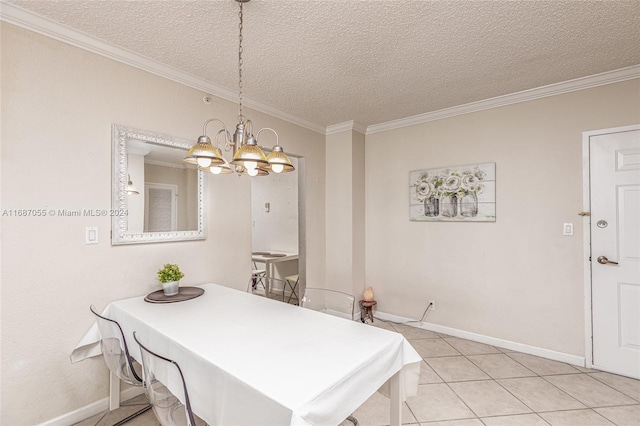 tiled dining room featuring a textured ceiling, ornamental molding, and an inviting chandelier