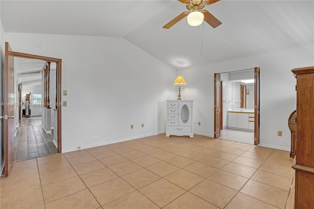 4706 SE Manatee Ter, Stuart, FL 34997 - empty room featuring lofted ceiling, ceiling fan, light tile patterned floors, and baseboards
